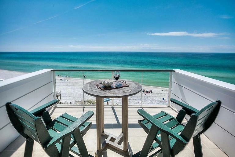 Beachfront balcony with two chairs overlooking turquoise ocean